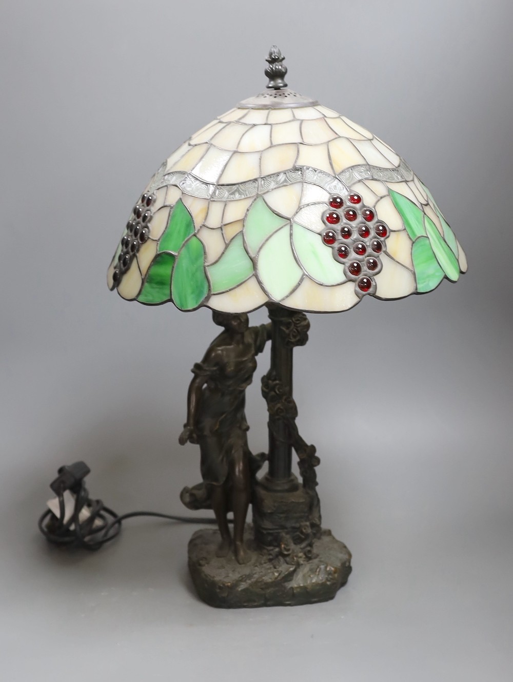 A figural table lamp with Tiffany style shade 47cm